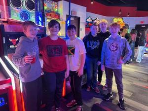 Several students are pictured in front of arcade games.