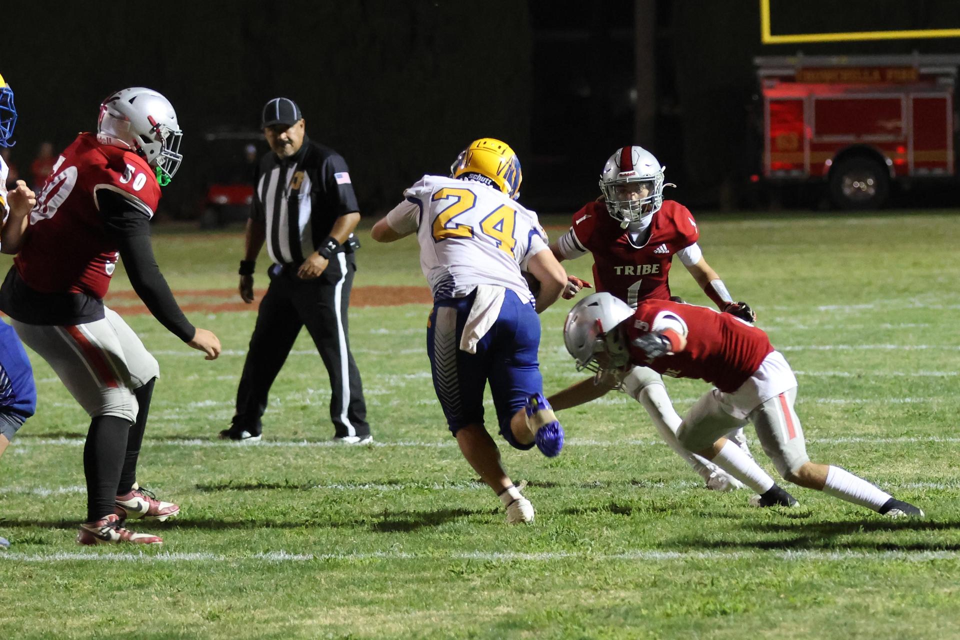 Varsity football players in action against Parlier 77