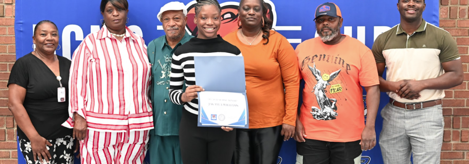 A picture of student and her family receiving scholarship