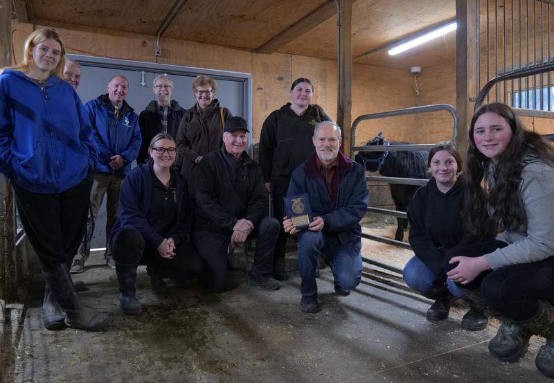 The rainvilles, principal, ag department teachers and students pose with a plaque of appreciation