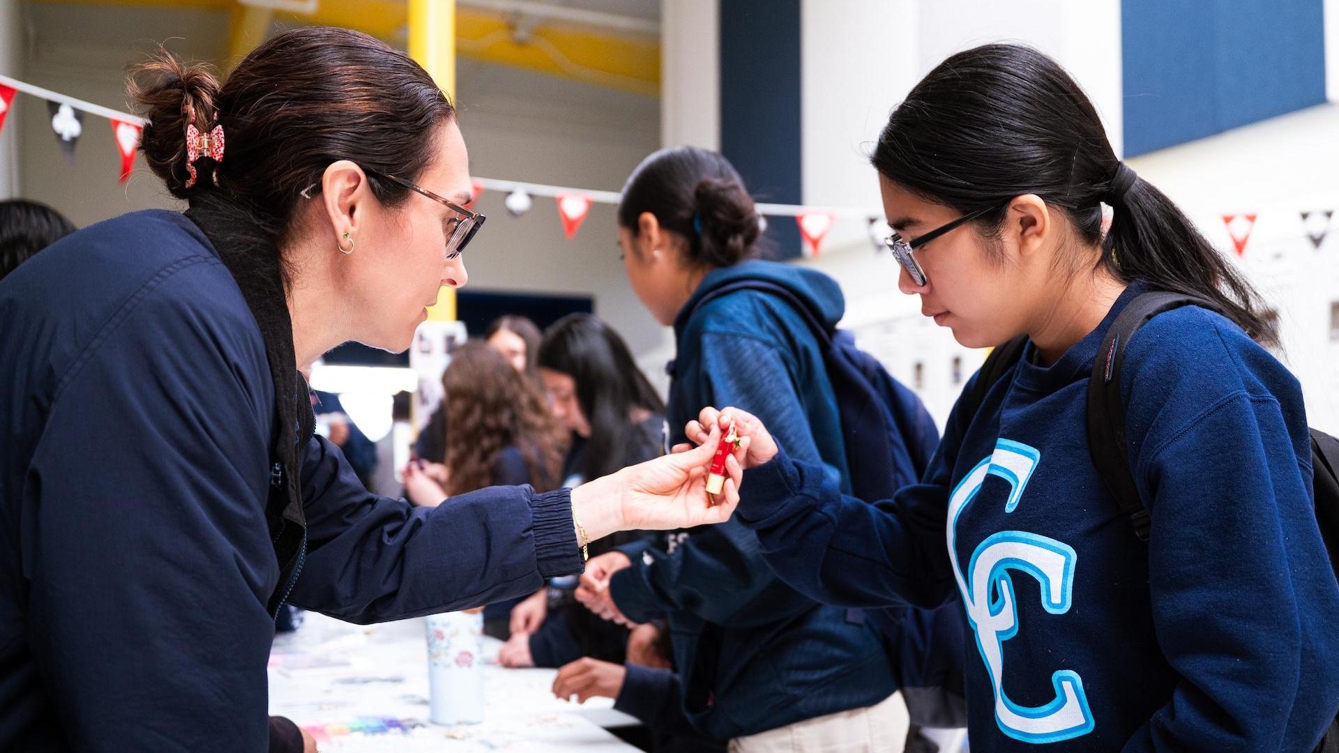A teacher assists a student at an event with various activities in a school setting.