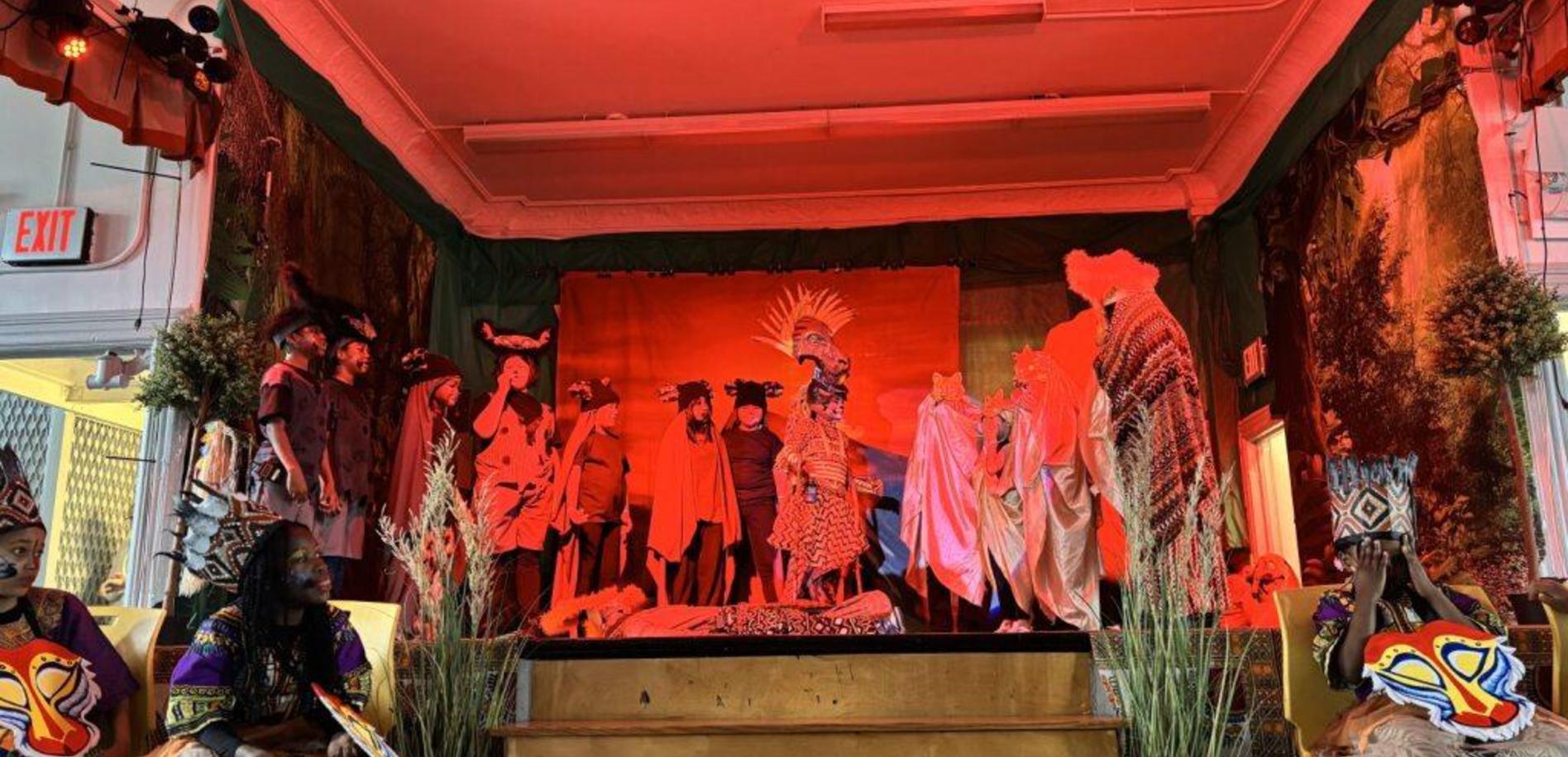 A vibrant stage performance featuring performers in traditional costumes and dramatic lighting.