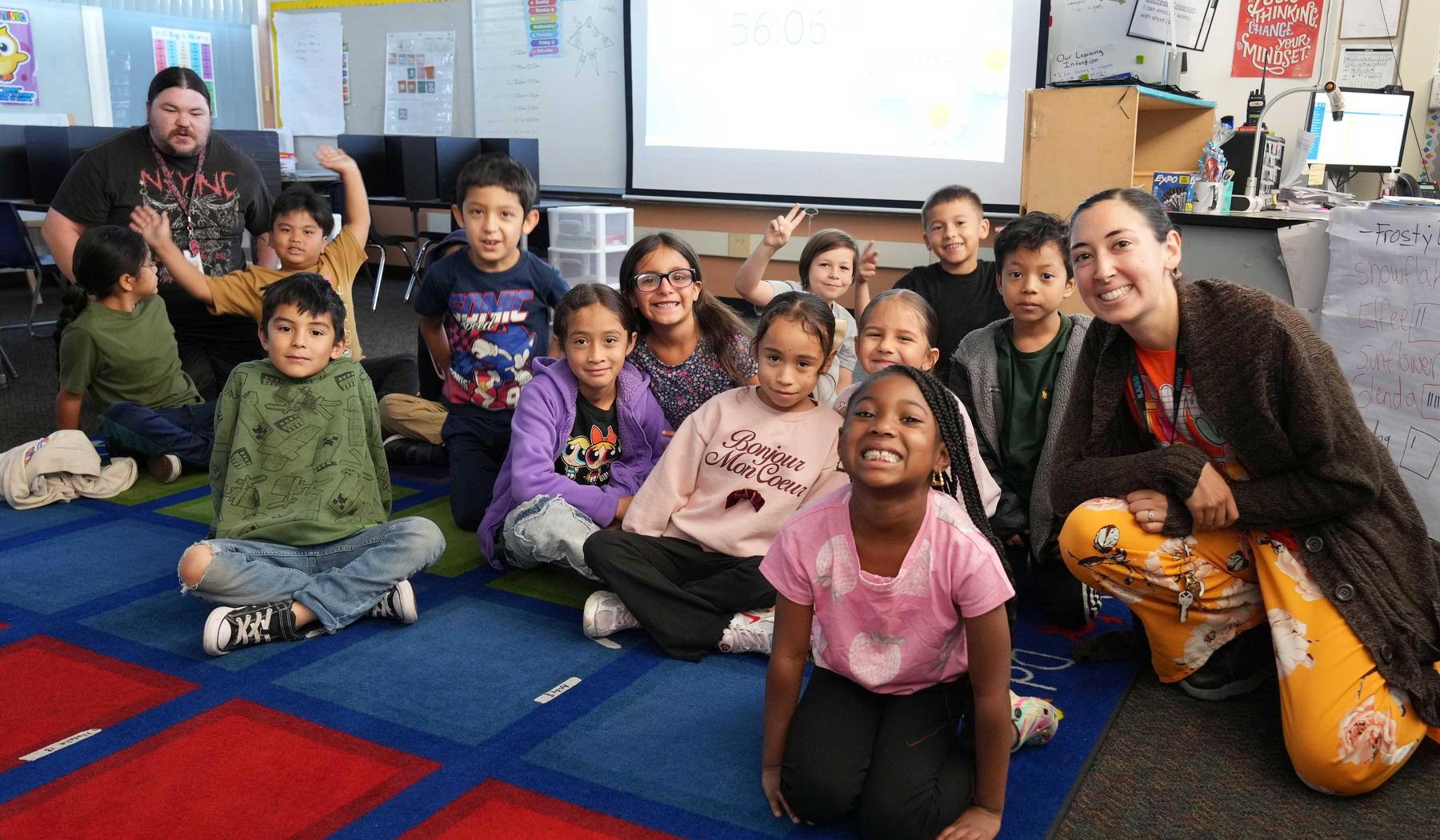 Students, Instructional Aide and Teacher sitting on the classroom floor