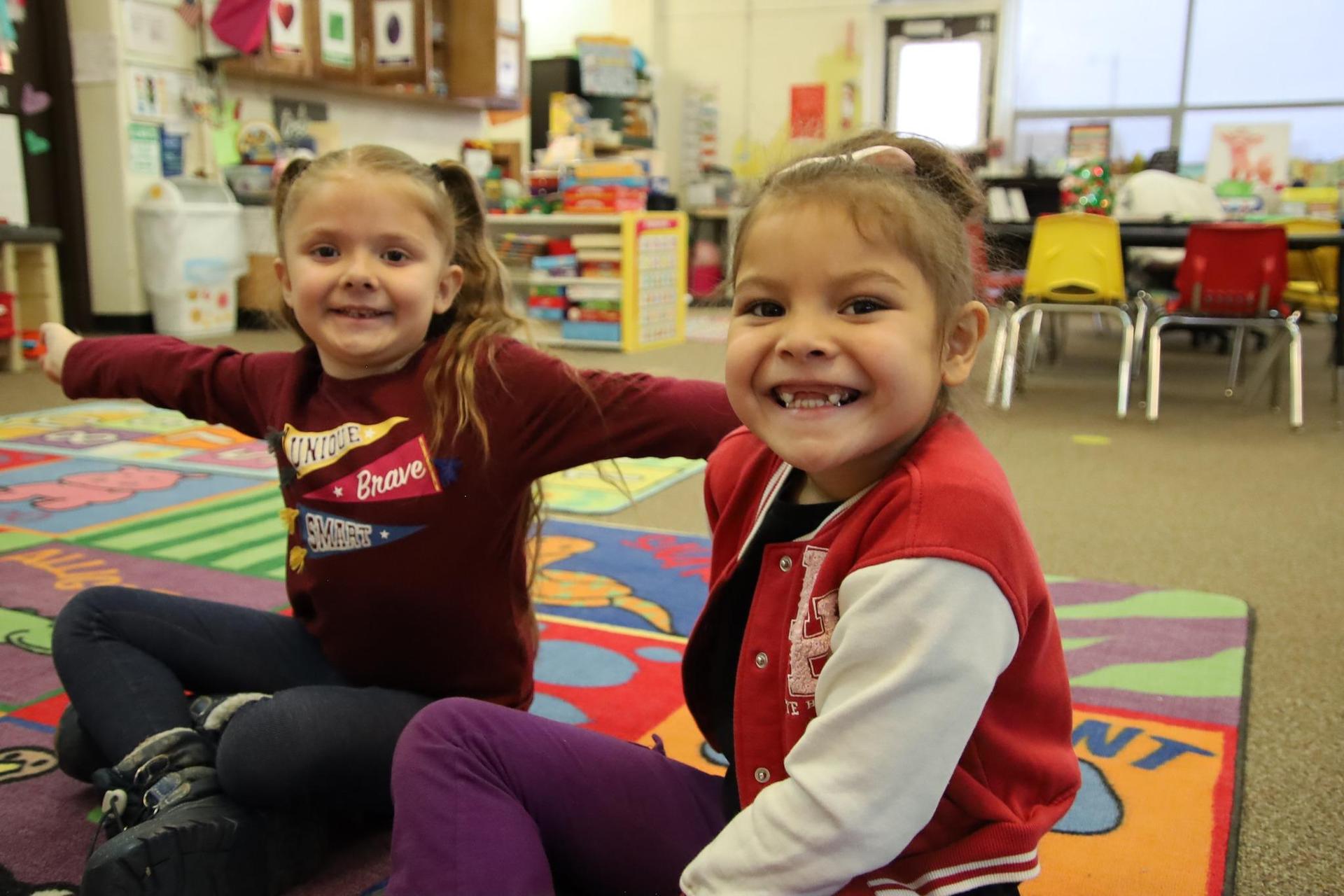 Two students smiling in a classroom