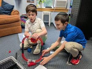 Two boys construct a lever system