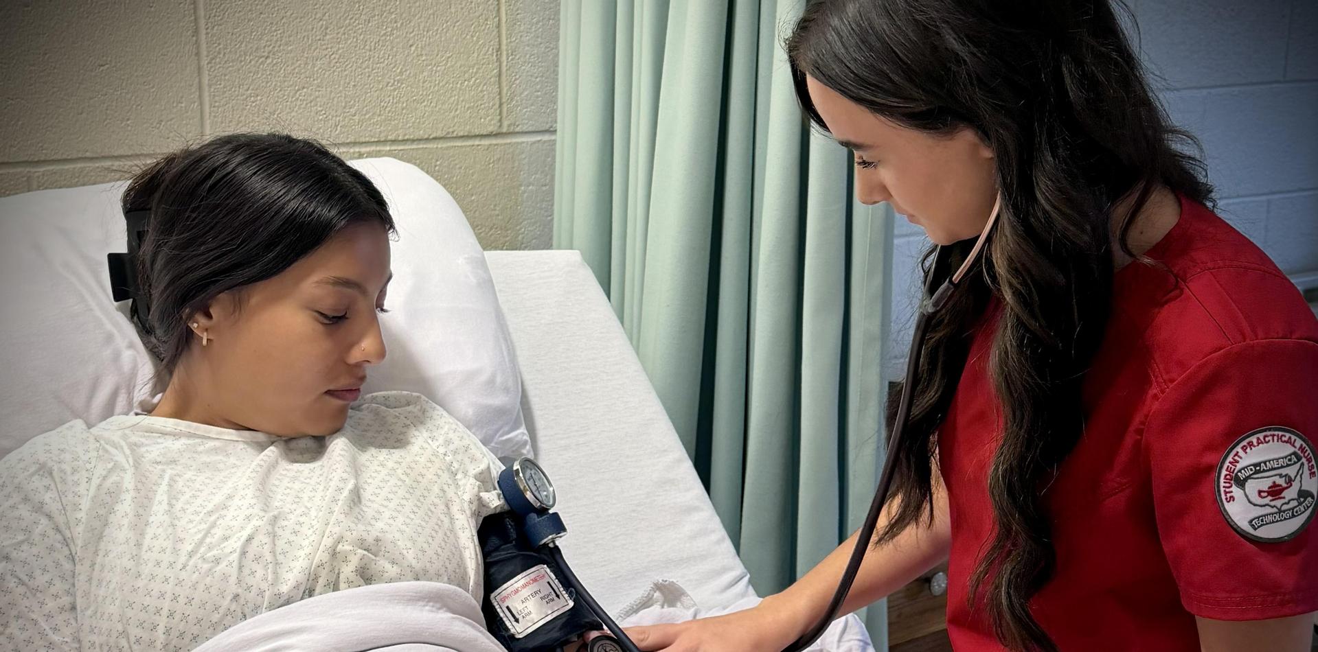 A nurse measures a patient's blood pressure in a hospital setting.