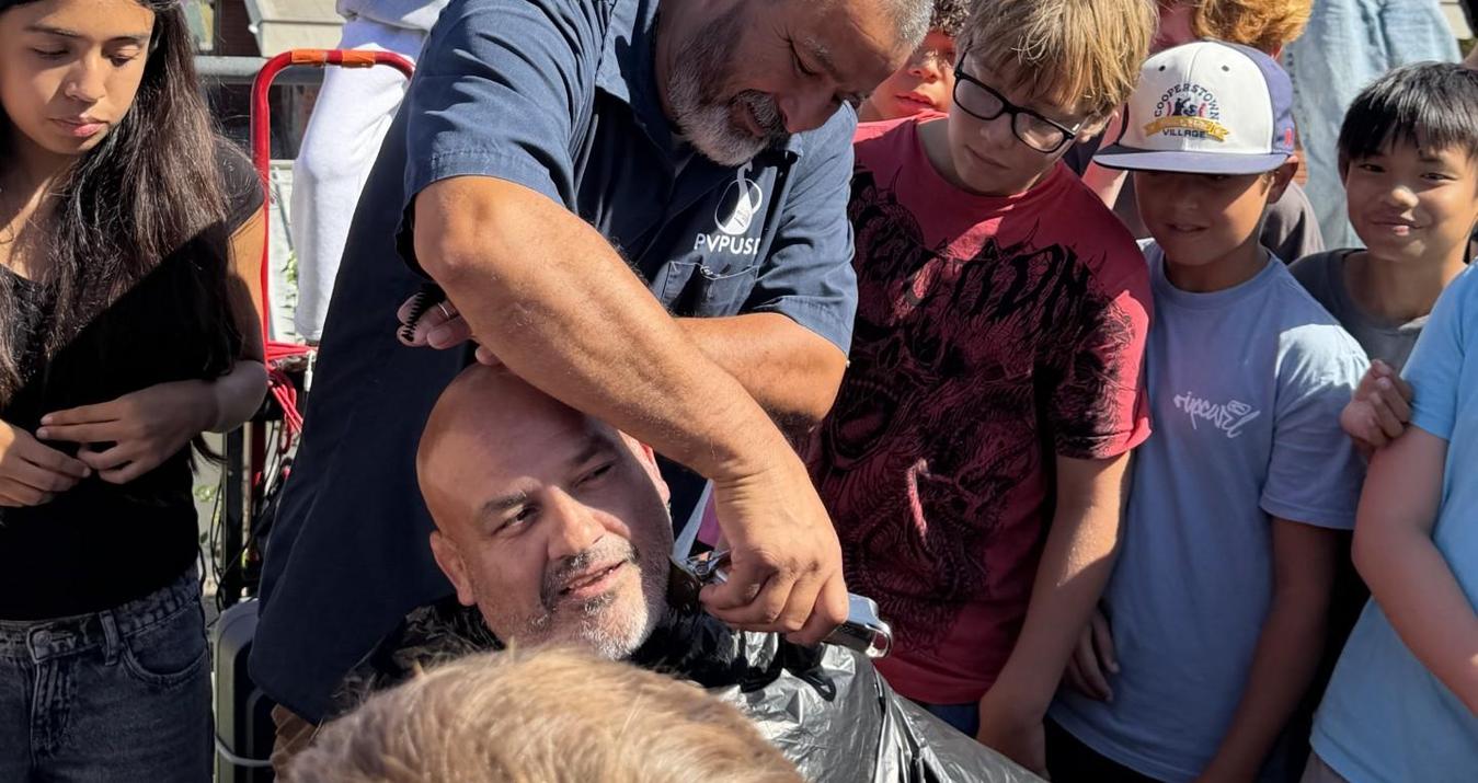 Man interacting with kids in a casual outdoor setting.