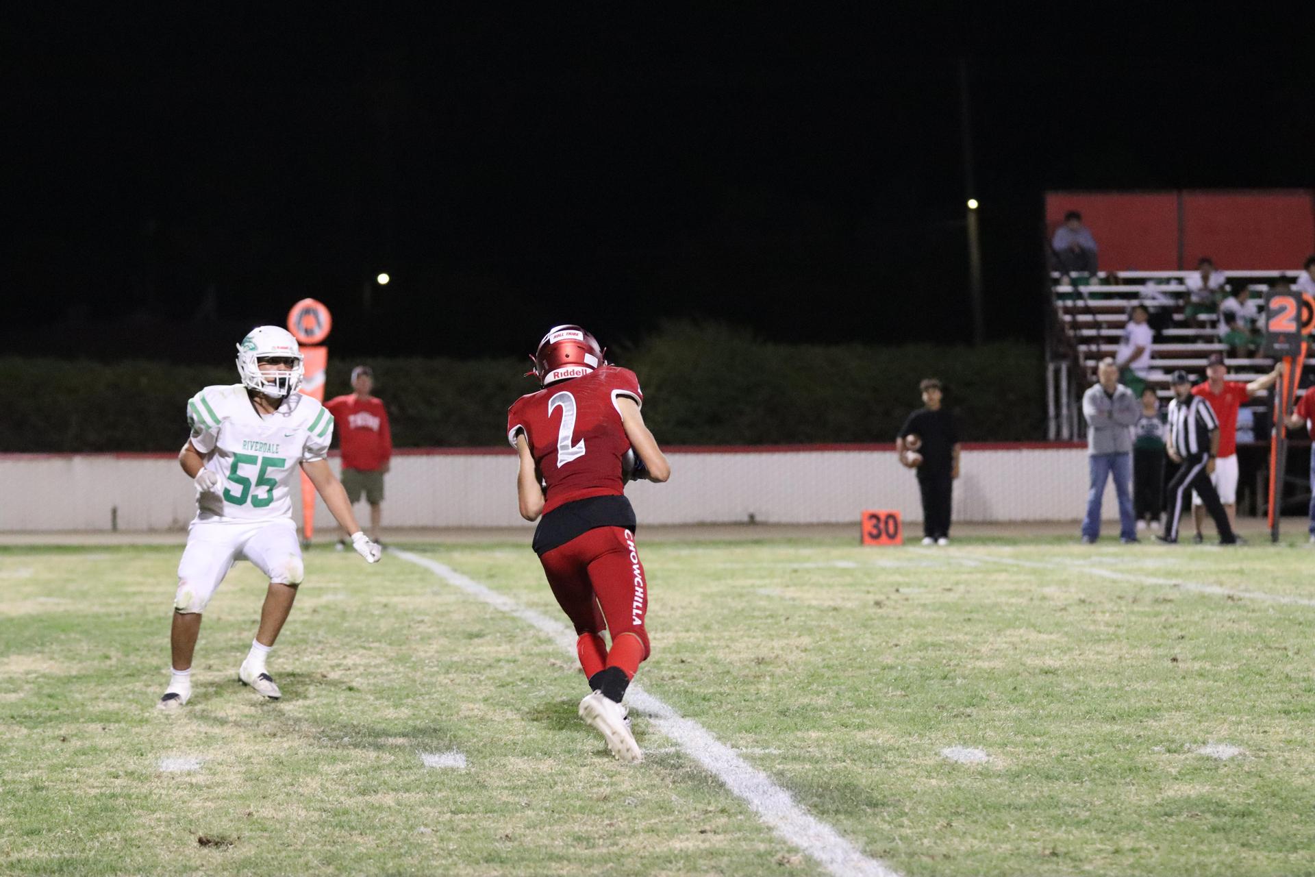 varsity football players in action against Riverdale