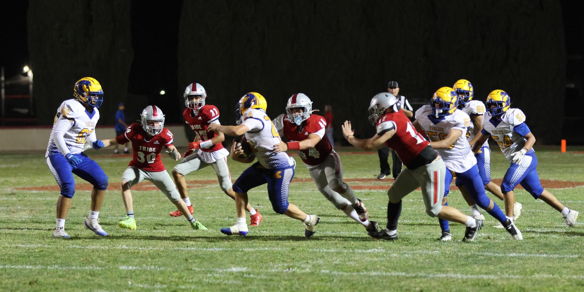 Varsity football players in action against Parlier 100