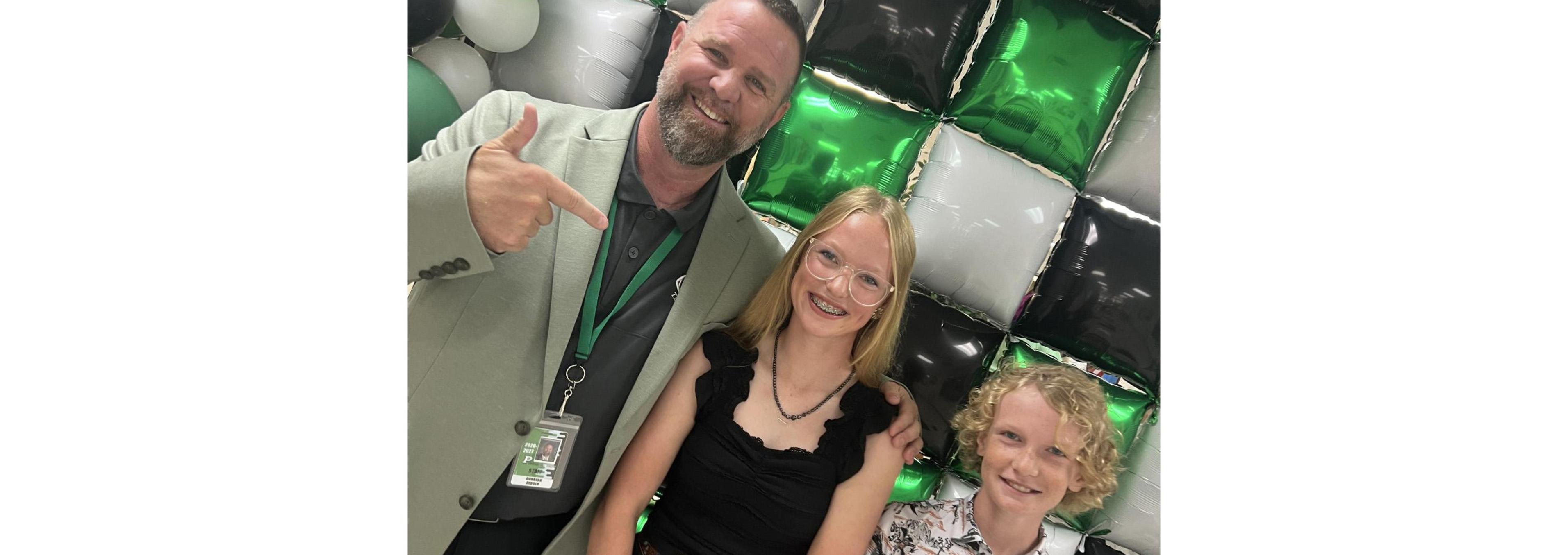 Dr. DeBoer posing for a picture with two Pierre students at Check-in Day.