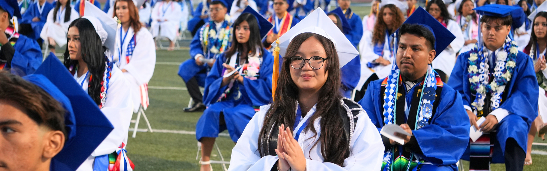 Graduates sitting with caps and gowns at a ceremony