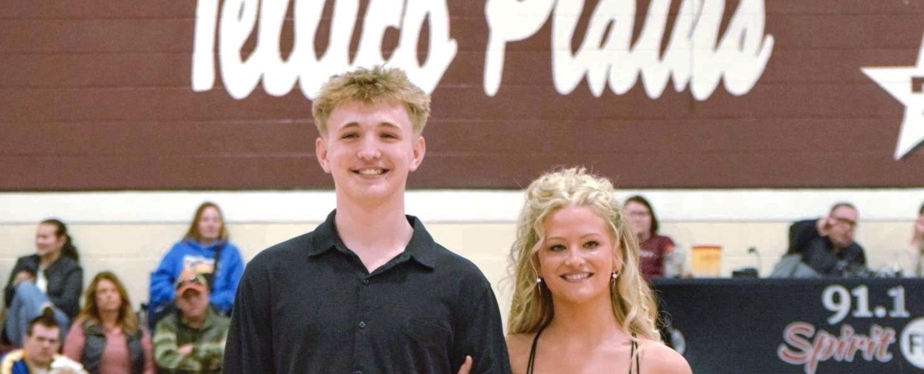 Couple dressed elegantly on a basketball court, with a rose in hand.