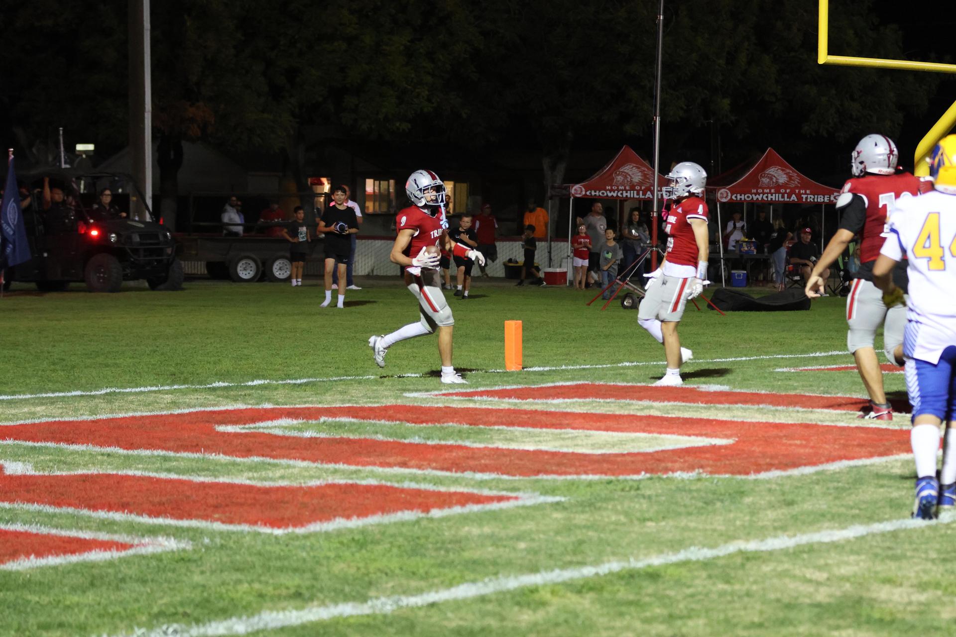 Varsity football players in action against Parlier 17