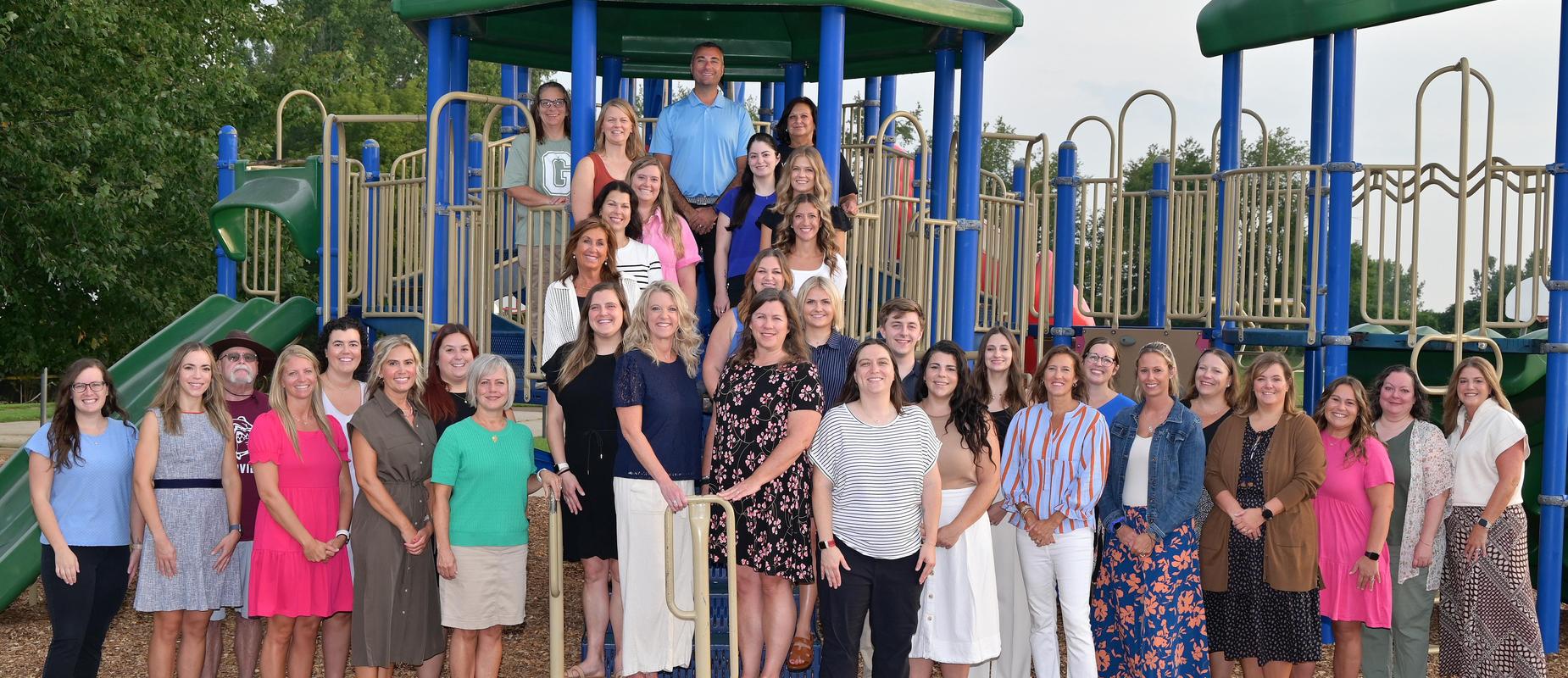 staff portrait of GV staff all standing outside on the playground smiling