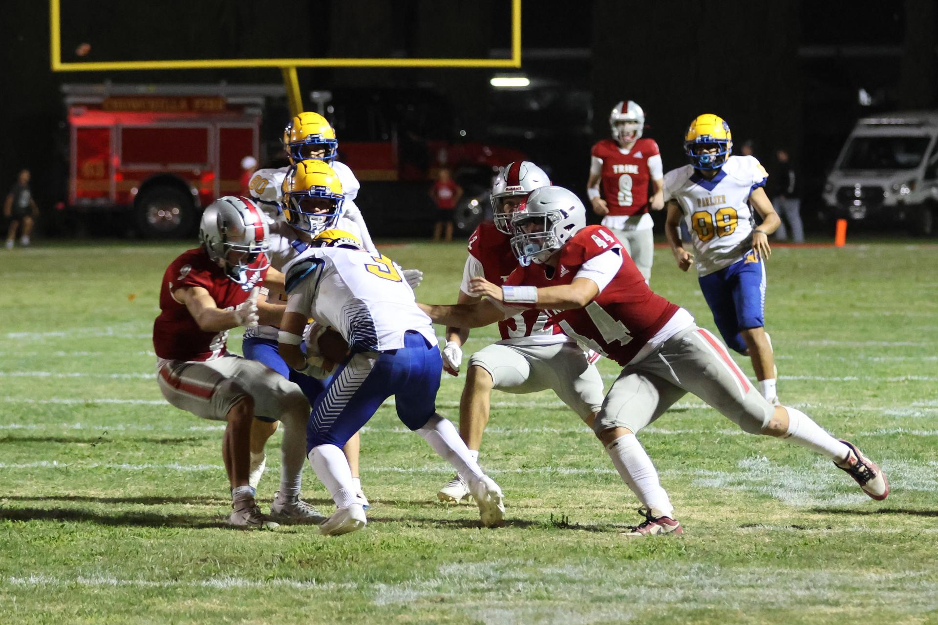 Varsity football players in action against Parlier 72