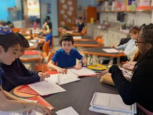 Second grade boys work with Mrs. Carter on their animal reports.