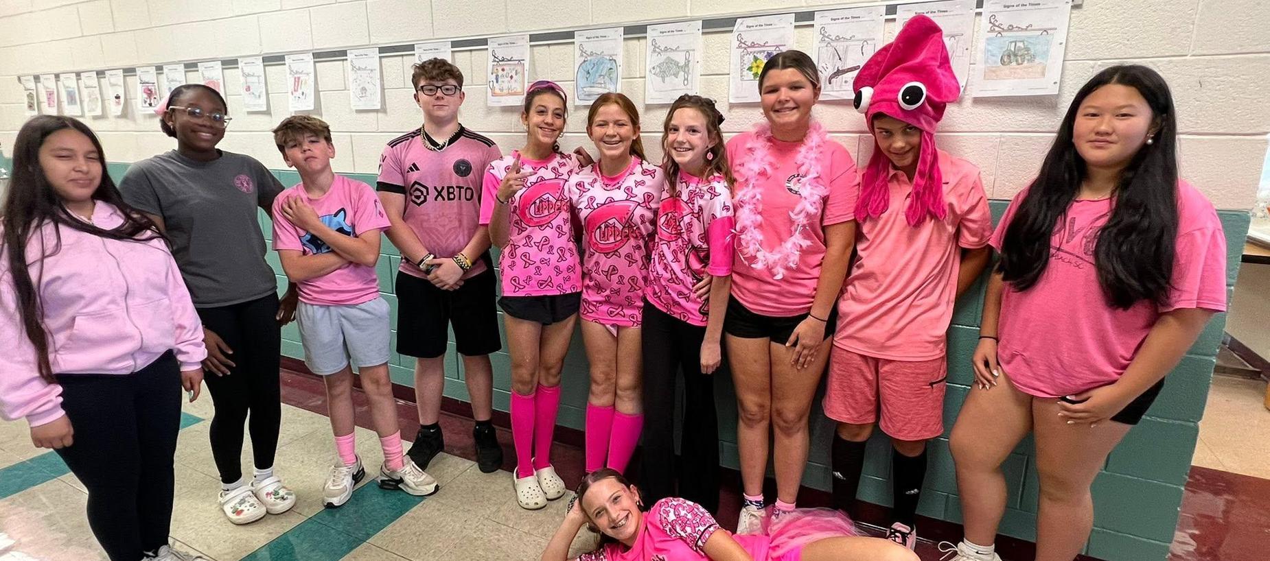 Group of students dressed in pink outfits for a themed event.