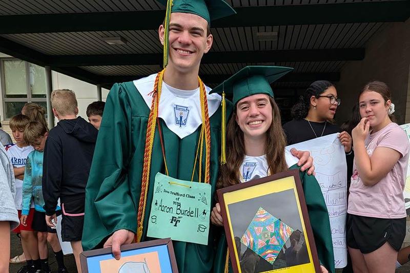 Aaron Burdell and Annabelle Aquino hold their elementary artwork while visiting Harrison Park for their walk through celebration