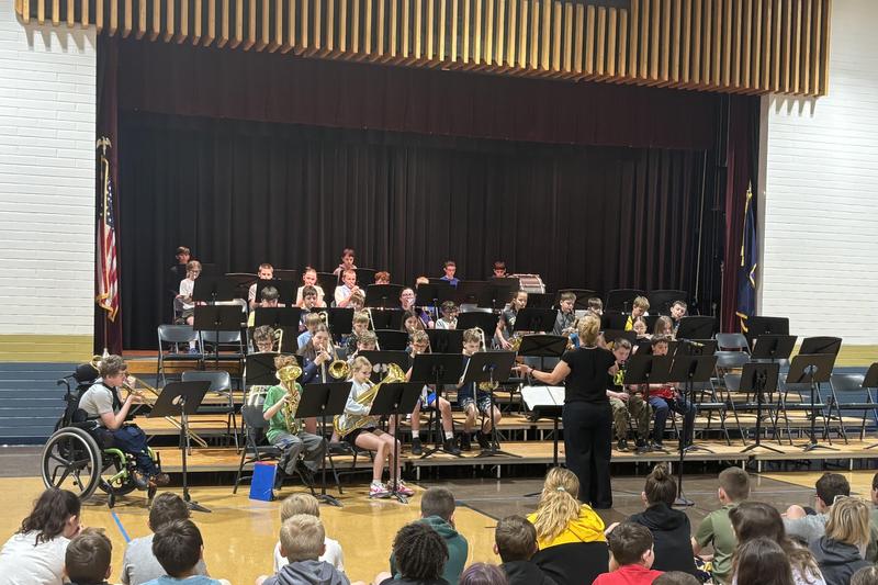 band performs on stage in front of school