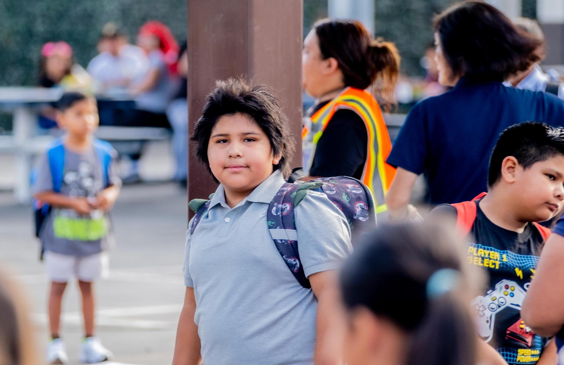 student smile at camera as he waits in line