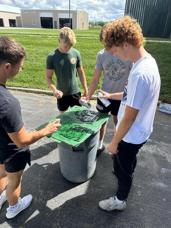 Students in Woods 3 put the finishing touches on senior athletic plaques