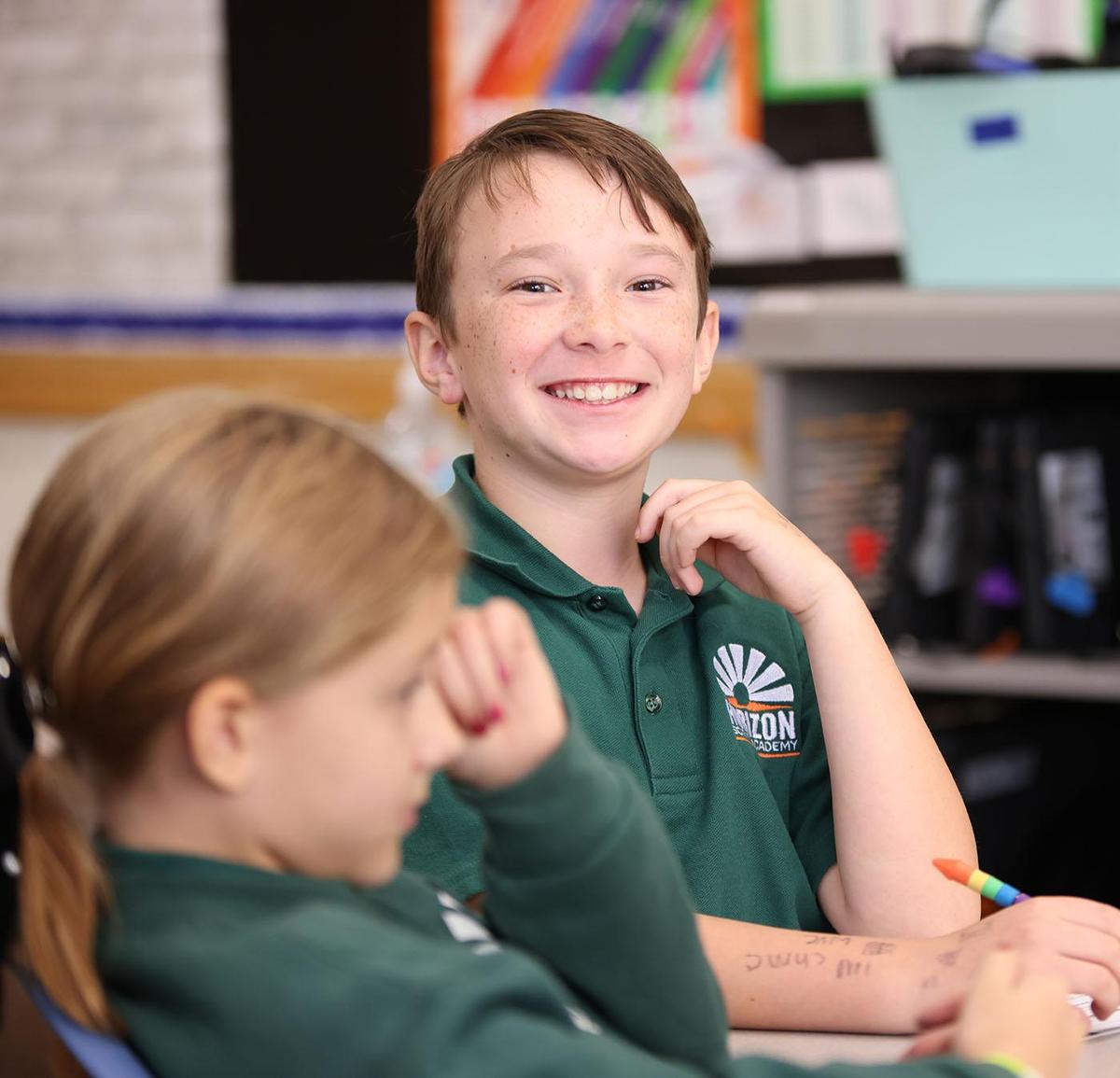 HSA Davenport student writing at a desk in a classroom setting