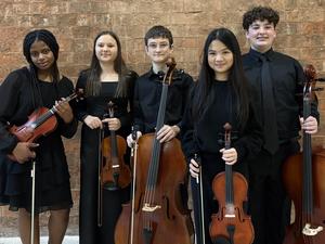 Image of 5 middle school orchestra members holding their violins