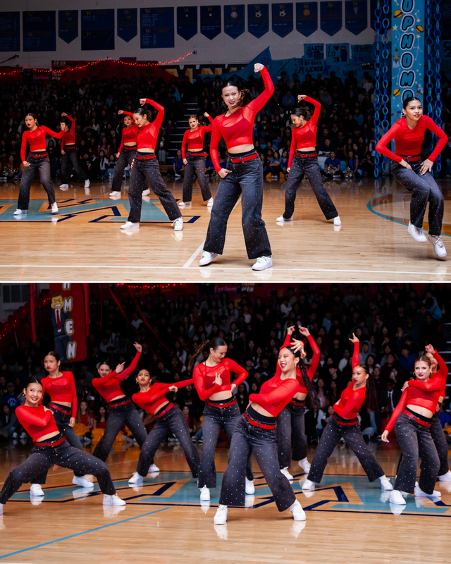 Dancers in red tops and jeans performing a synchronized routine on a gym floor before an audience.
