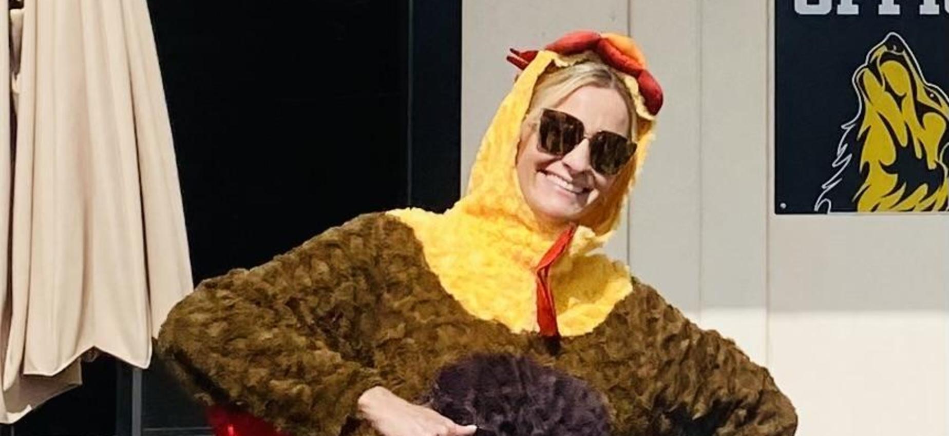 Person wearing a humorous brown turkey costume with red accents.