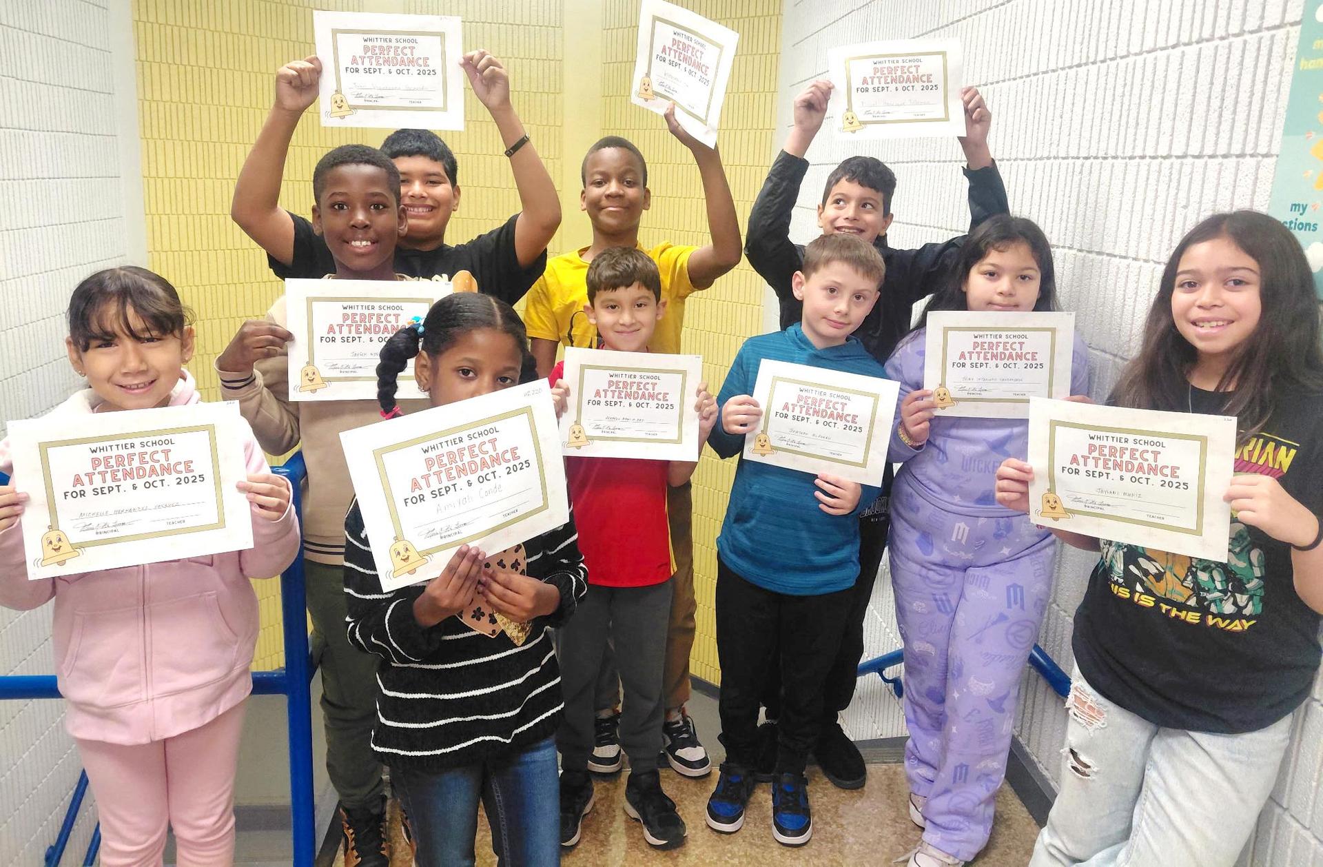 Group of students celebrating perfect attendance with certificates in hand.