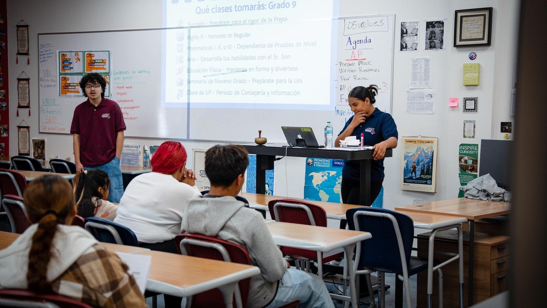 A teacher presenting to students in a classroom setting.