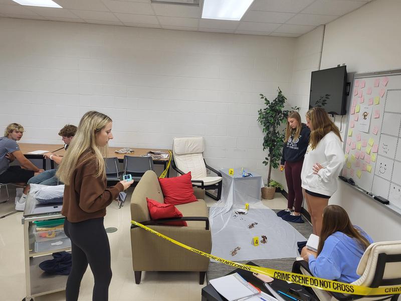 forensic science students looking at a crime scene