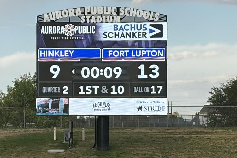 Scoreboard displaying game scores and time in a stadium setting for Fort Lupton Flag football.