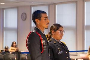 two cadets at the school board meeting podium
