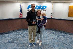 Kevin Cruess holds his recognition award and poses with his family at the PUSD Board meeting.