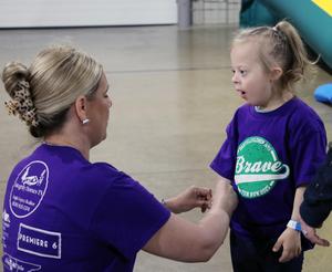 Teacher applying wristband to student arm