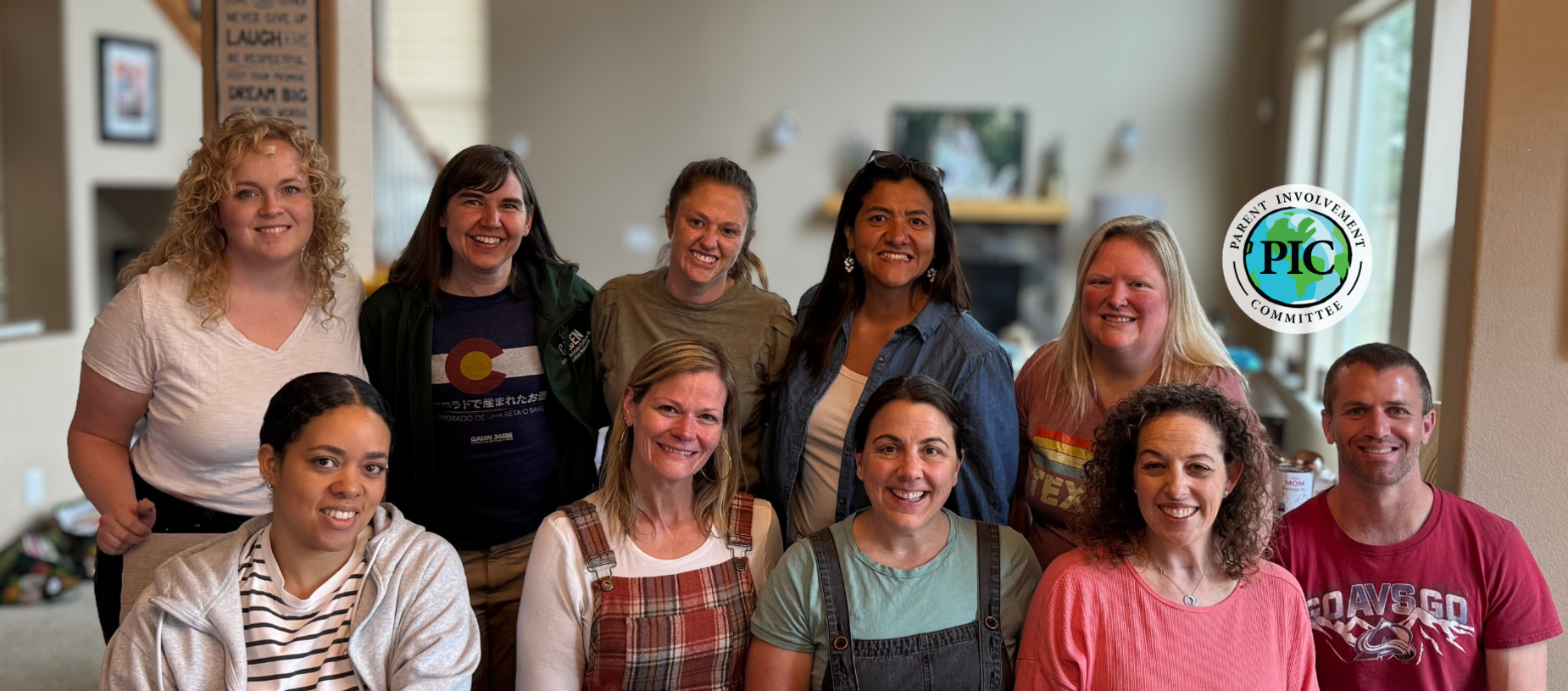 Group of people smiling together in a cozy indoor setting.