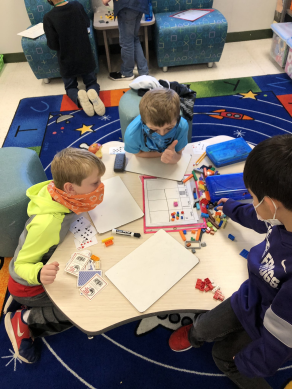 3 young boys working together at school table