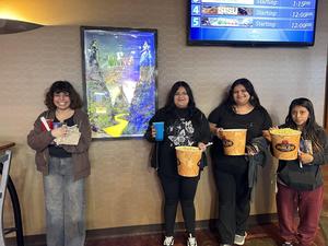 Gresia and friends standing in front of movie poster