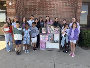 Westwind students and MHS students posing with handmade dollhouse