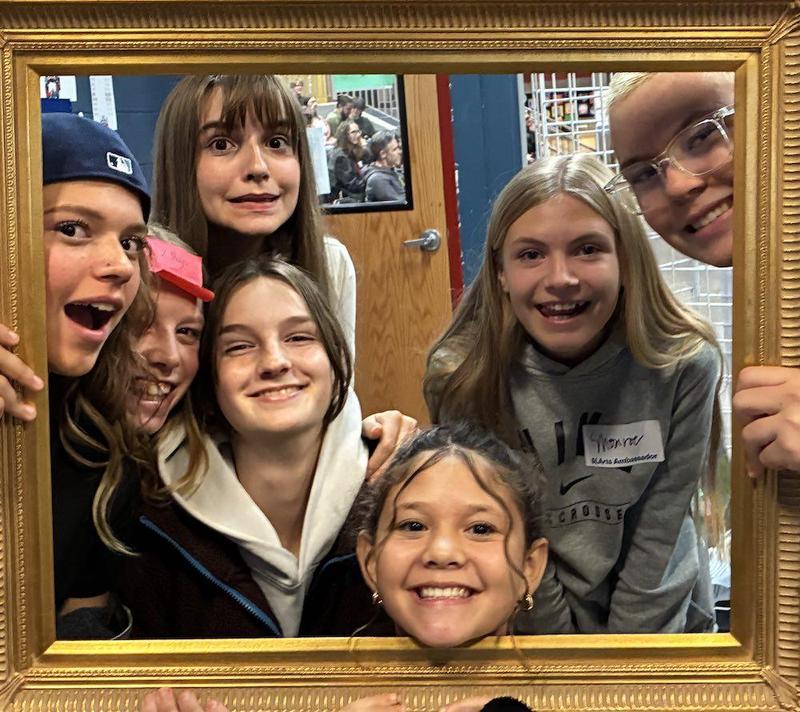 Five teen girl faces inside an open frame as they are smiling