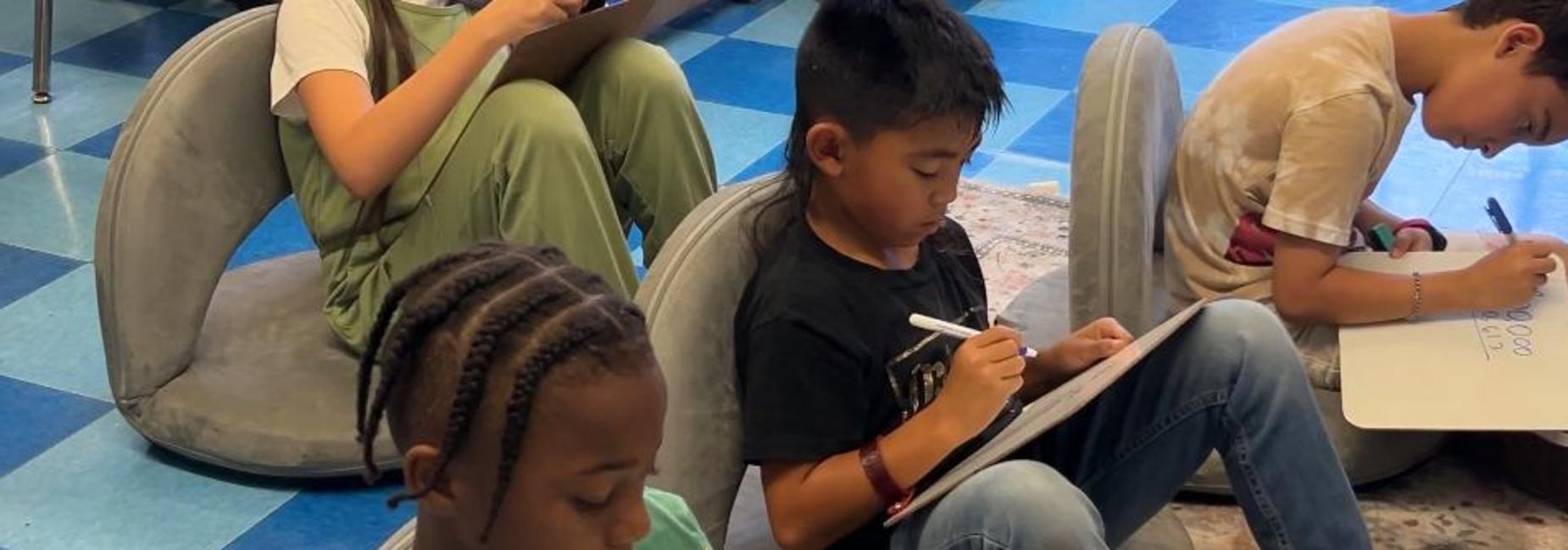 students on rug working on white boards