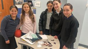 Girls pose with their unfinished portrait