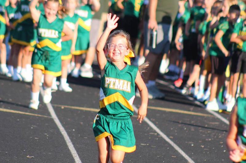Tomahawk cheerleader and 1st-grader, Hannah Kaninberg, waves to spectators