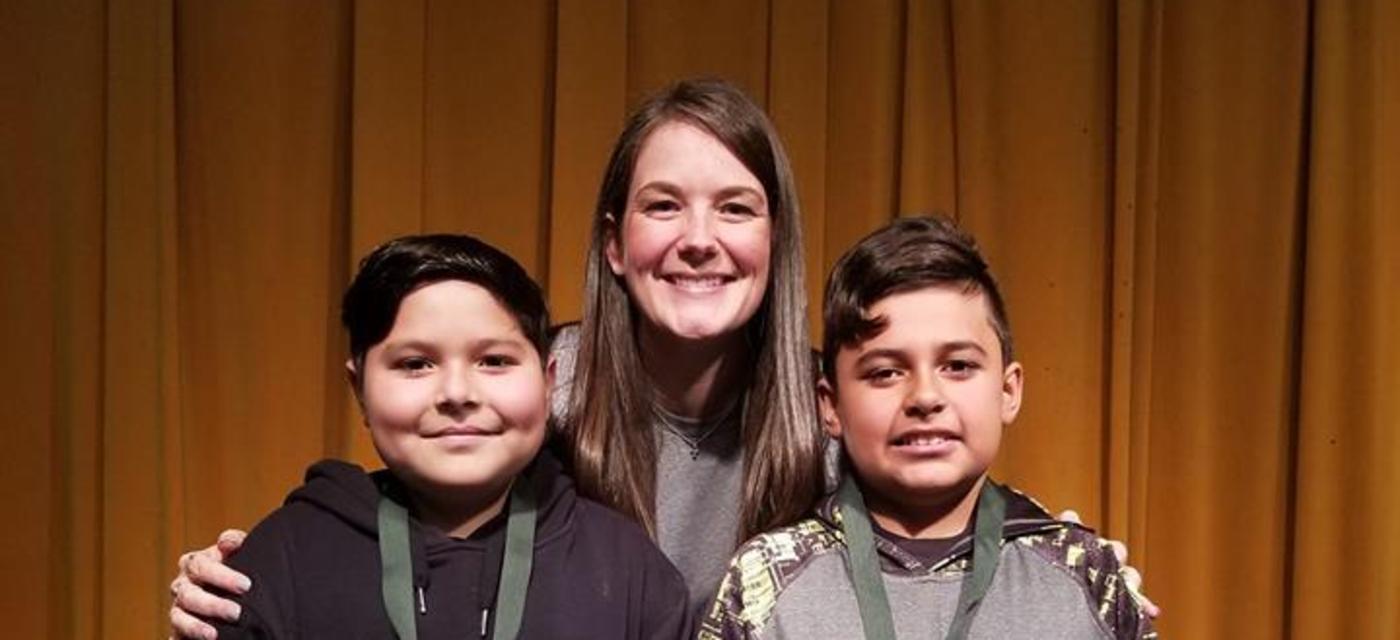 2 spelling bee winners and a teacher on stage