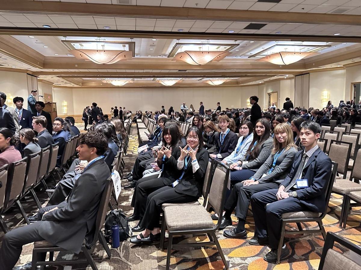 A large conference room filled with attendees seated in formal attire.