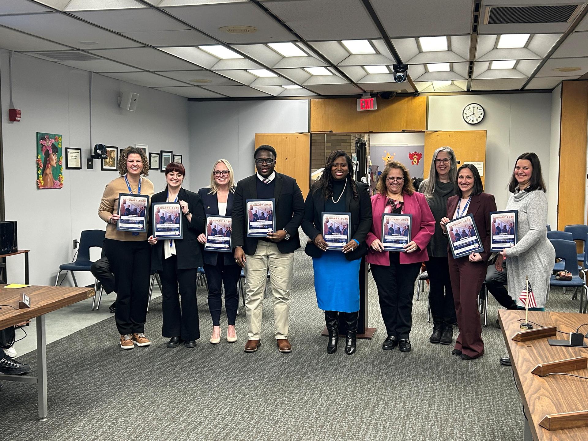Image of 9 men and women holding up their PSBA Board Director Recognition Certificates