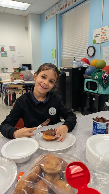 a second grader decorating a donut
