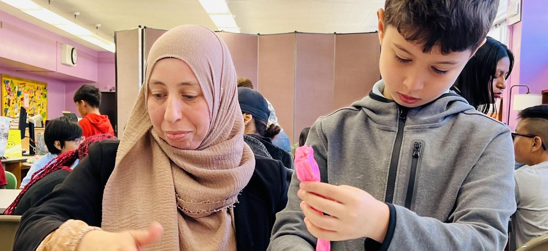 A female parent and student decorating cupcakes.