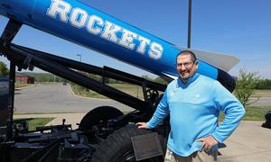 Principal Luker posing by Rocket outside school